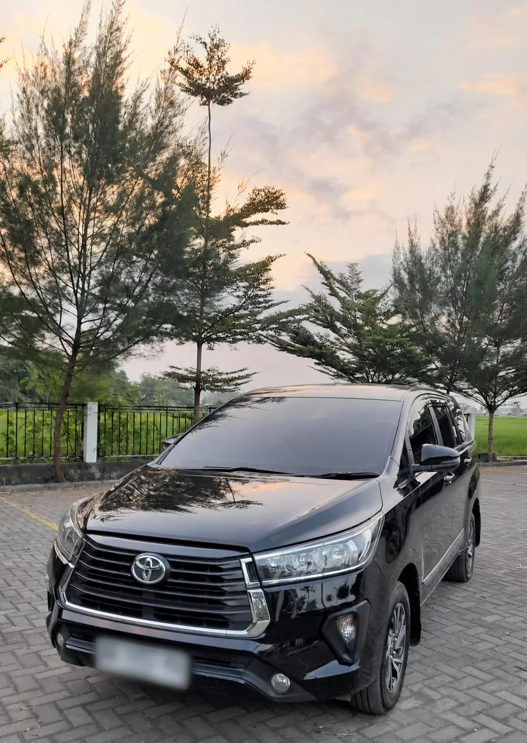Toyota Innova Reborn FC hitam tampak depan tiga perempat